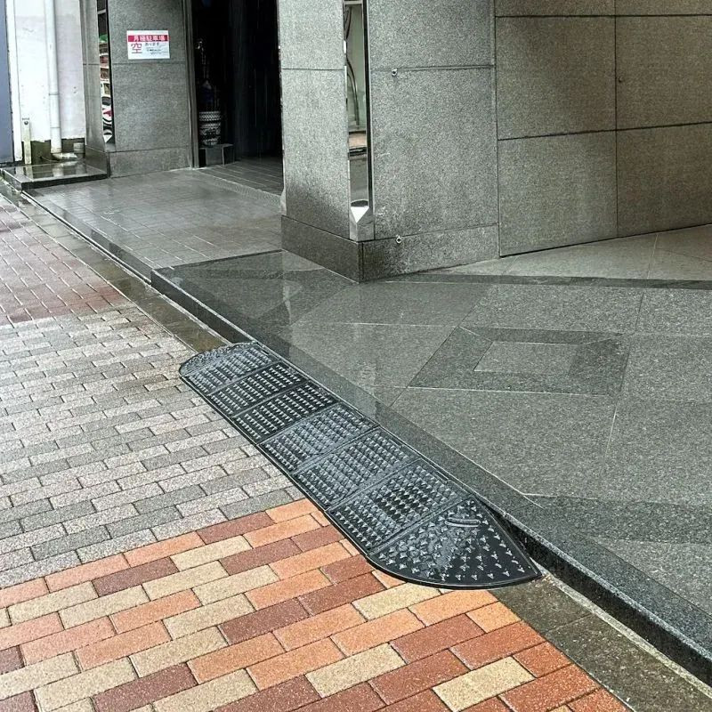 Rampe d'accès pour trottoir avec passe cables